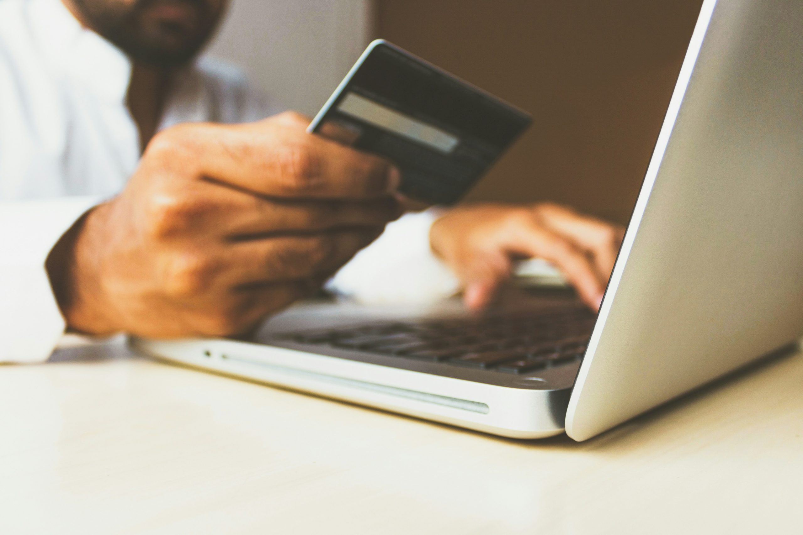 A person entering credit card details onto a laptop.