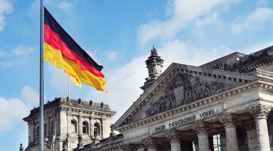An image of the german flag flying over government buildings.